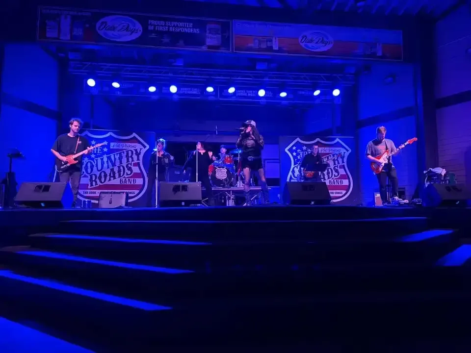 The Country Roads Band performing under blue stage lights at Oahe Days in Pierre, South Dakota